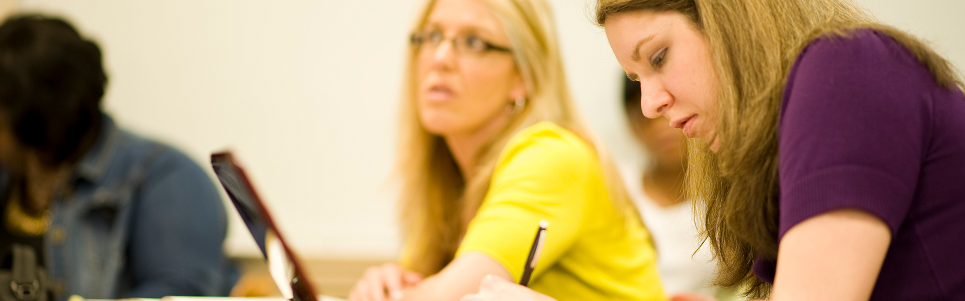 Adult students taking notes in classroom