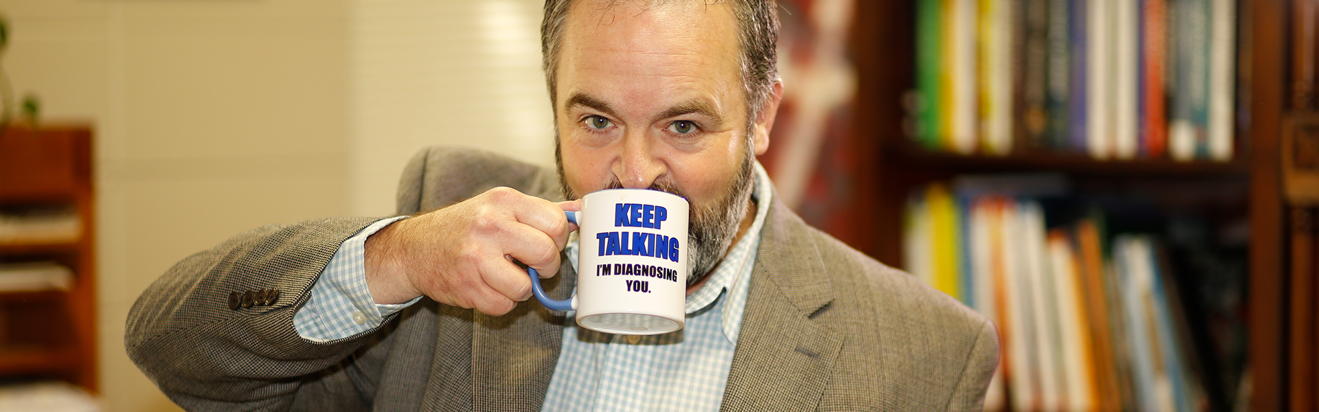 Psychology professor drinking from mug
