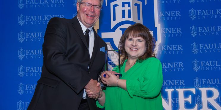 Allena Burbage receives the Distinguished Alumna Award from President Mitch Henry.