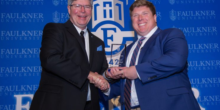 Ben Kissinger receives the Accomplished Alumnus Award from President Mitch Henry.