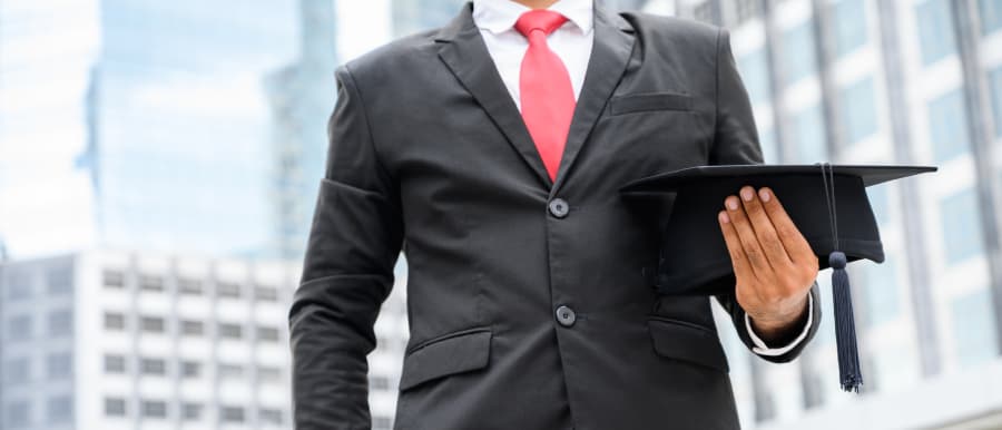 Business professional holding graduation cap