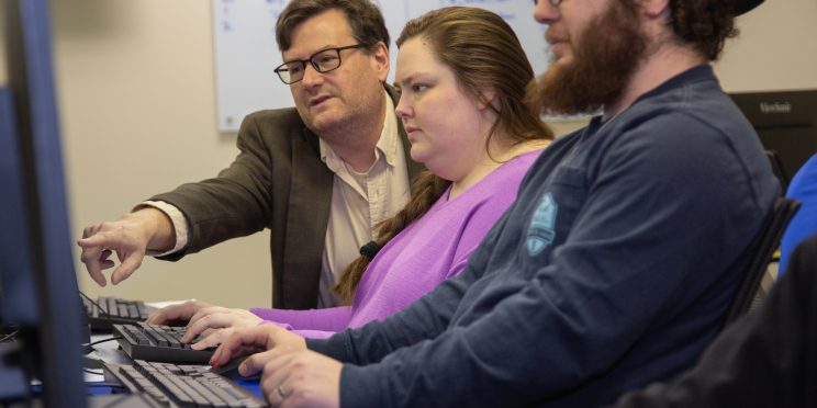 Mike Herridge, left, helps Computer Science students.
