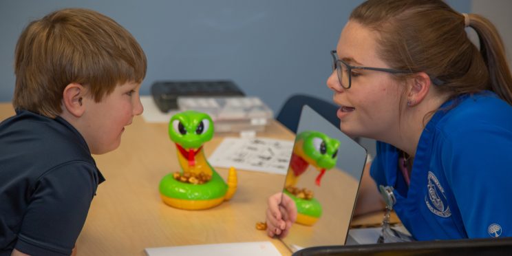 A young patient works on his speech therapy inside the clinic.