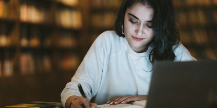 College student studying online at library
