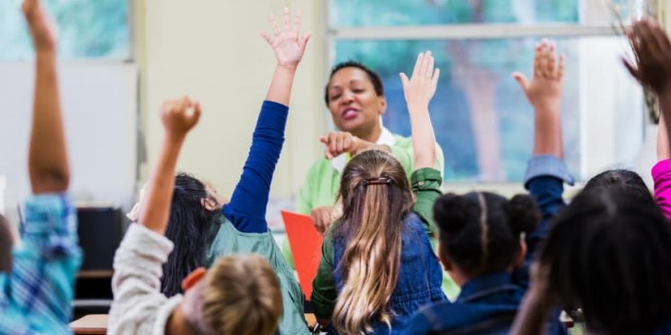 Elementary School Teacher And Students In Classroom