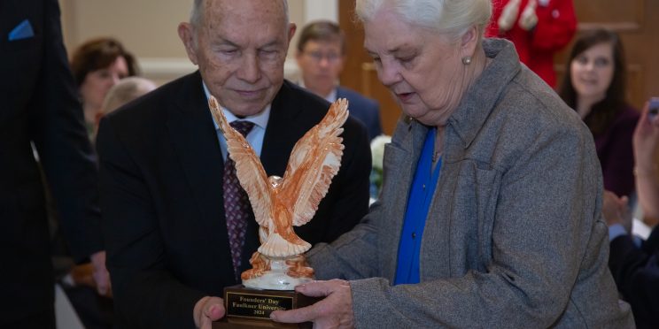 Beau Greer and Joy Greer accept a special Alabama Clay Eagle in honor of their family on Founders Day.