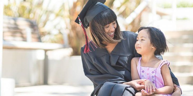 Female Graduate Sitting with a Young Girl