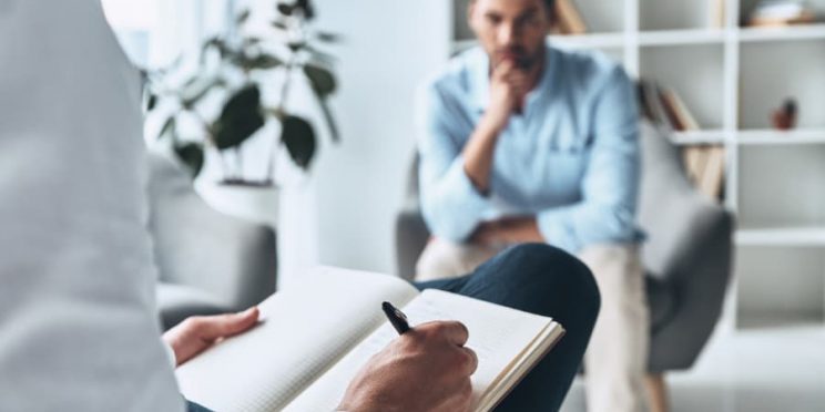 Psychologist Writing Notes While Working With Patient