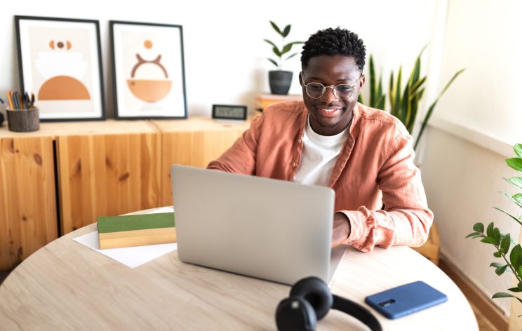 Graduate student sitting with laptop while participating in online class