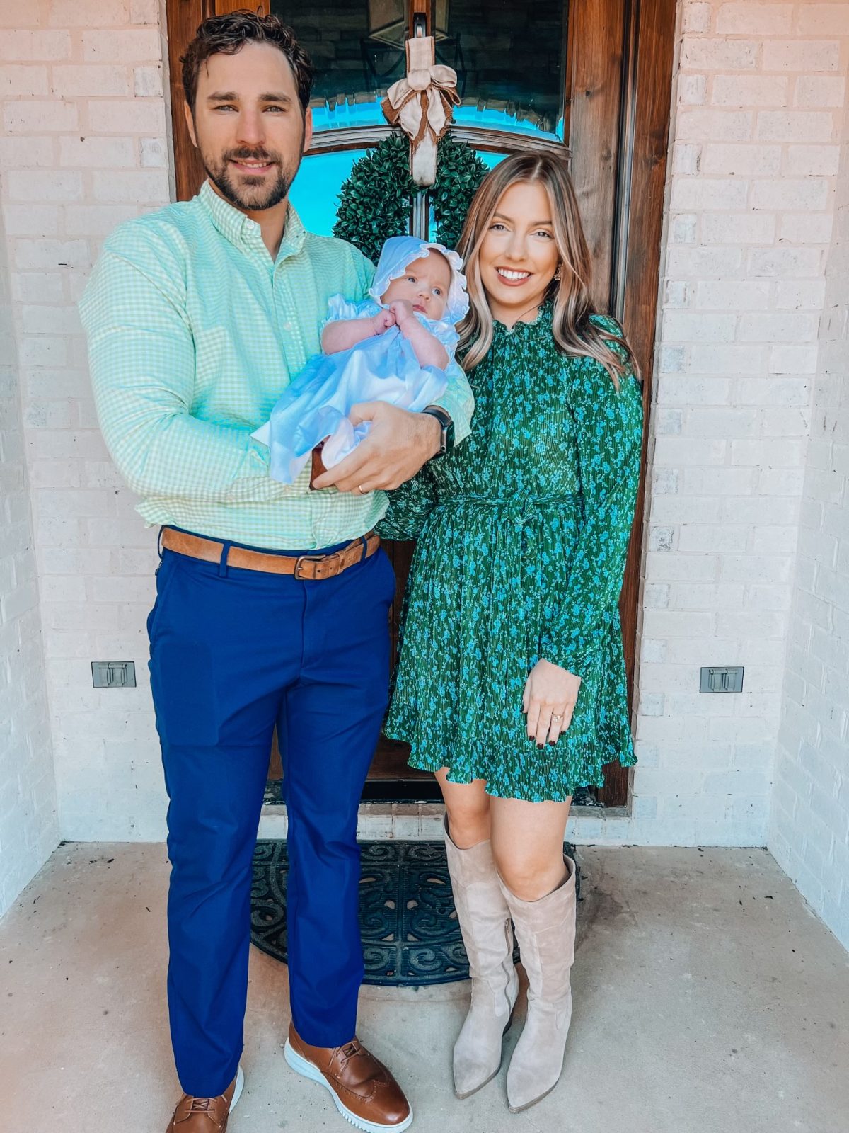 l-r, Hunter Wilson, wife McKenzie and daughter Maren pose for a family photo in front of a door.