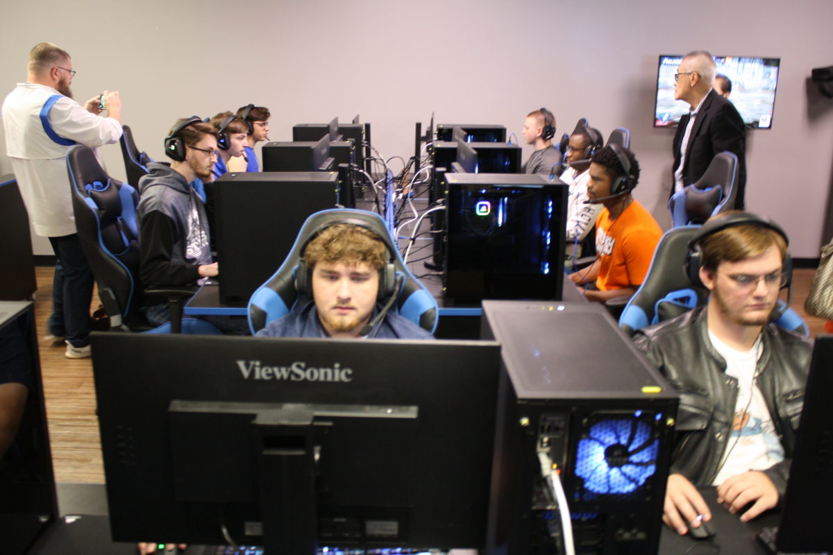 Esports team members demonstrate the capabilities of the arena to guests.