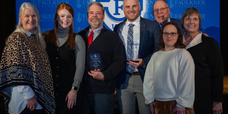 Joey Burns, center left, stands with his family after being awarded Distinguished Alumnus.