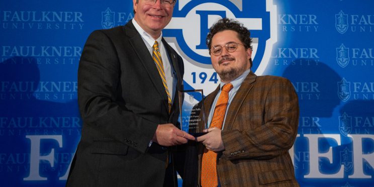 President Mitch Henry awards Jacob Payne. Payne works as a lawyer in Dothan, Alabama.