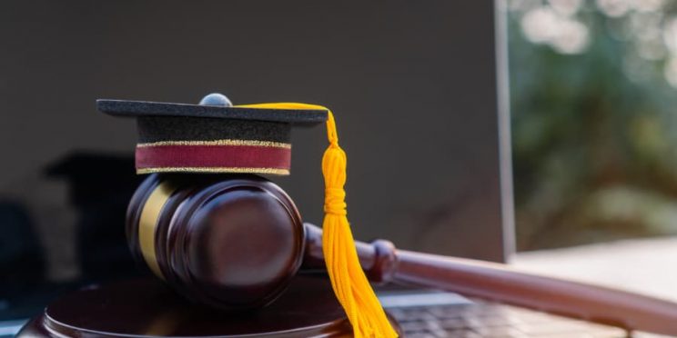 Laptop Beside Judge’s Gavel And Graduation Cap