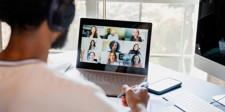Online degree student interacts with professor and classmates via laptop from home
