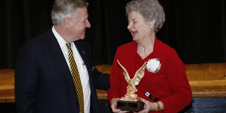 Olivia Mae Burt accepts the Alumna of the Year Award from Faulkner President Mike Williams.