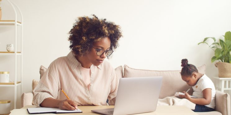 Parent studying online with child in background