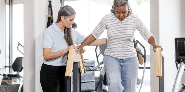 Physical therapist working with patient recovering from surgery