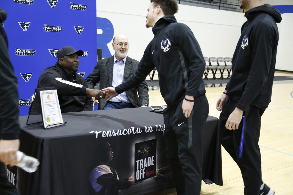 Alfy Smith shakes hands with the Faulkner Men's Basketball team.