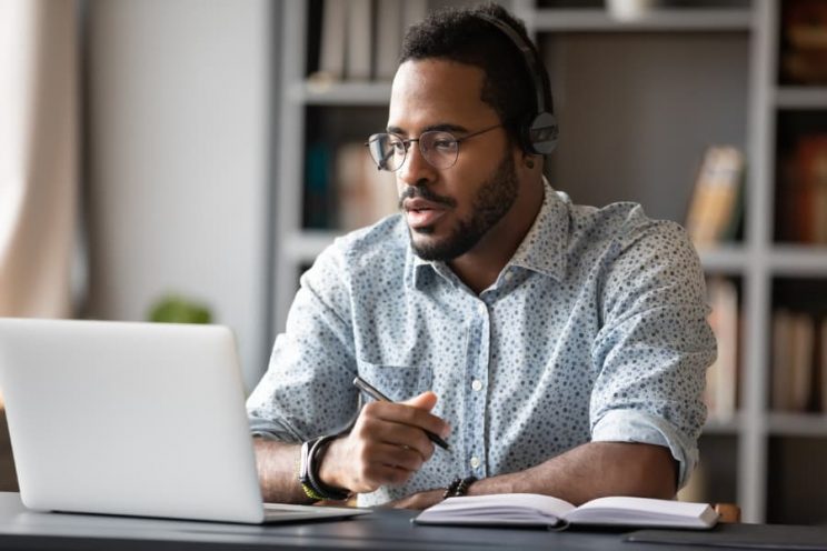 Student wearing headset working on laptop
