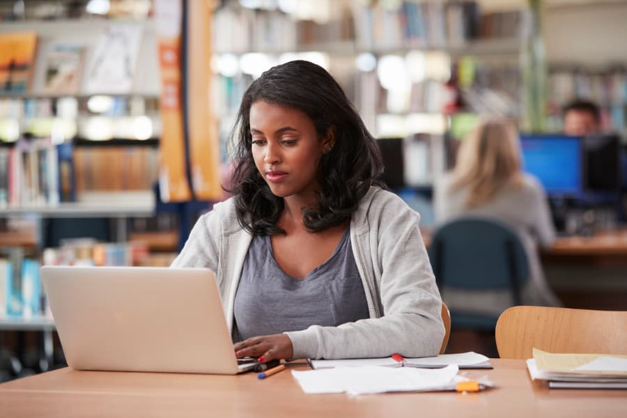 Student working on laptop in library