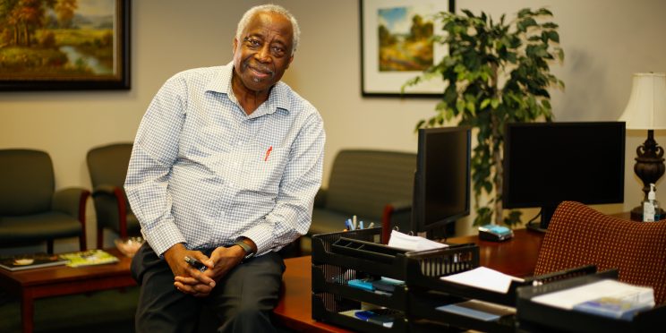Michael Walcott sits on his desk.