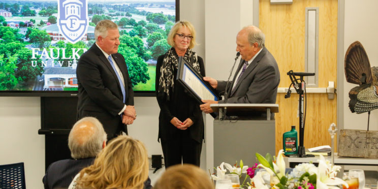 Dale Kirkland, right, reads the resolution to Mike and Lisa Williams, to name the autism center the Mike and Lisa Williams Center of Autism.