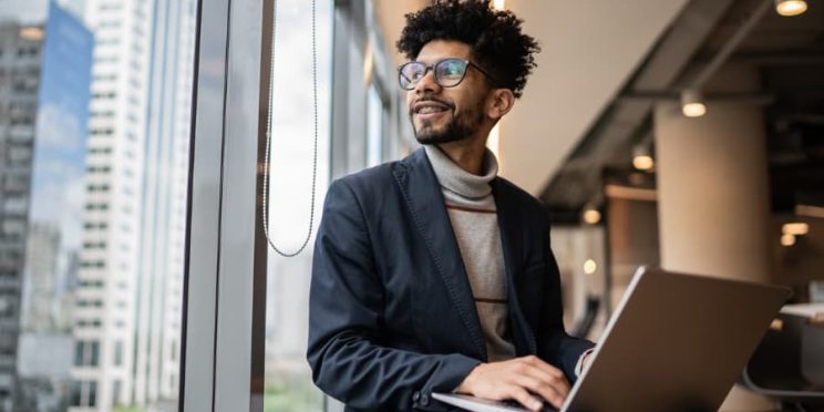 Businessperson with computer, looking out window