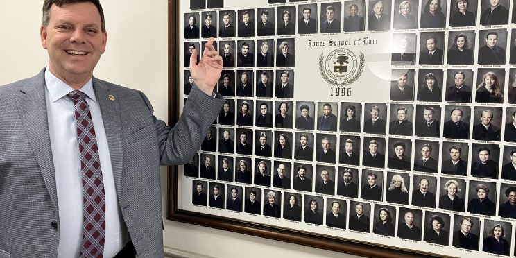 Daryl Bailey points to a picture of himself with the Faulkner Law graduating class of 1996.