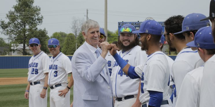 Lamar Harrison shares a fist bump with a Faulkner Eagles Baseball player.