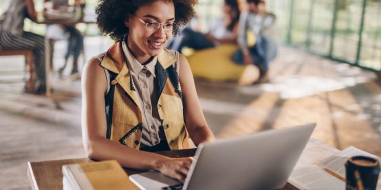Student sitting in coffee shop working on laptop