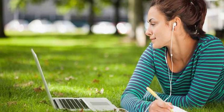 Student Studying in the Park with Earbuds